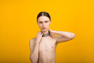 Feminine young man with metal chain. Slender body