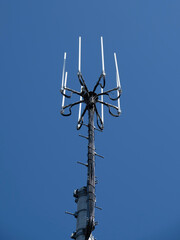 青空にそびえ立つ携帯電話基地局のアンテナ