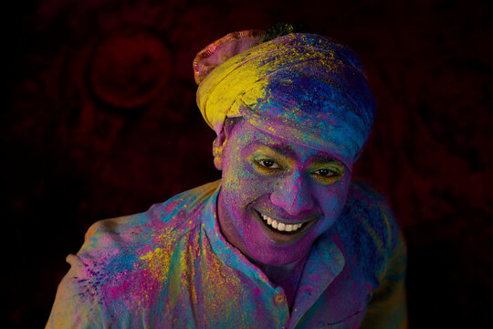 Man with gulal on his face celebrating Holi in excitement	
