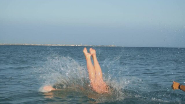 girl at sunset dives into the sea in slow motion. Relax