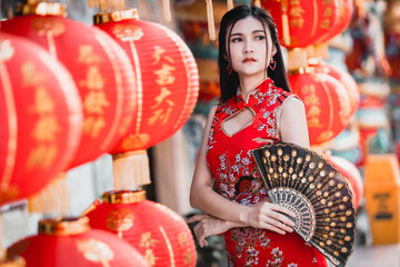 Asian woman wearing red traditional Chinese cheongsam decoration with paper lanterns with the...