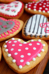 Fresh baked assorted lovely patterned heart shaped cookies on wooden breadboard	