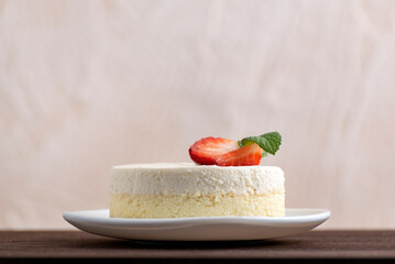 Delicious homemade cheesecake garnished with fresh strawberries. Side view