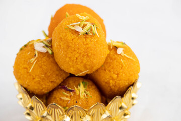 Delicious Motichur Laddoo Also Called Motichoor Laddu Sweet Mithai Originating From Indian Subcontinent. Meetha Ladoo Deep Fried In Desi Ghee Decorated In Golden Dessert Bowl. White Background