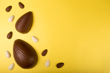 Easter. Composition with chocolate easter eggs on yellow background, space for text.