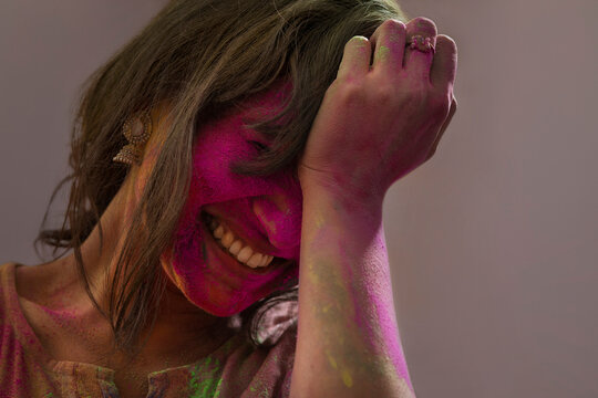 Woman smiling ecstatically  with gulal on her face on 