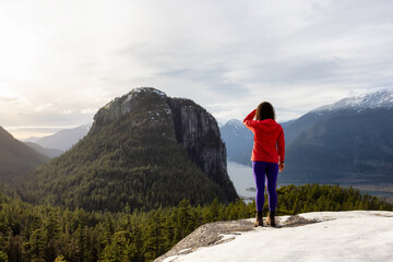 Fototapeta premium Adventurous Girl Hiking in the mountains during a sunny Autumn Sunset. Taken in Squamish, North of Vancouver, British Columbia, Canada. Concept: Adventure, freedom, lifestyle, health, sport