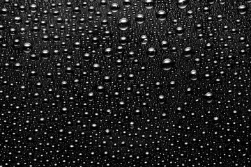background of drops on a black glossy surface close up