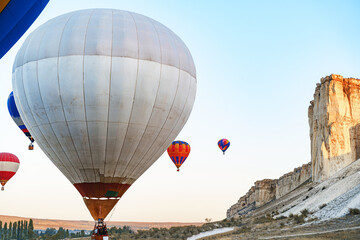 Obraz premium Colorful air balloons flying in clear sky near huge white mountain