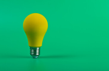 Yellow lamp on green background with copy space close-up.