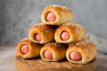 Homemade sausages in dough on a wooden board, fast food