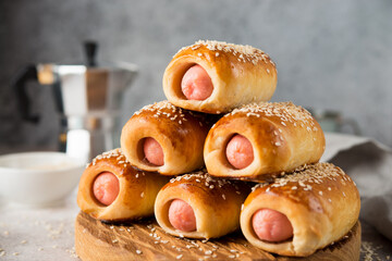 Homemade sausages in dough on a wooden board, fast food, close-up
