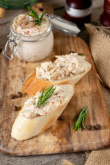 Chicken pate in a glass jar on the brown wooden kitchen table. Homemade chicken fillet pate with...