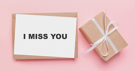 Gifts with note letter on isolated pink background, love and valentine concept with text I miss you