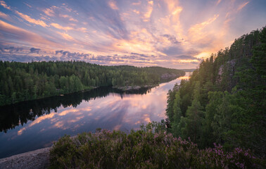 Scenic forest and lake landscape with tranquil mood and colourful sunset at summer morning in Finland - 410073769