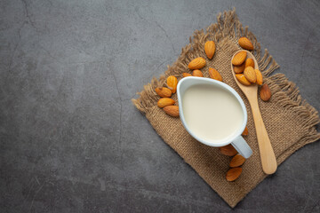Almond milk with almond on dark background