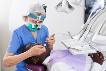 Dentist professional filling teeth for man patient sitting in medical chair. High quality photo
