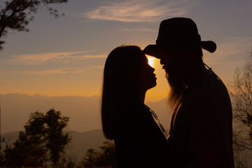 Fototapeta na wymiar Young couple enjoying the sunset in the mountain