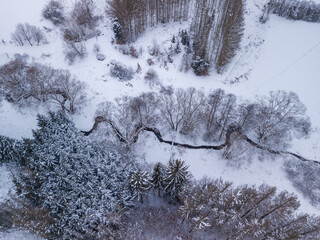 Aerial view of partially deforested landscape with creek, winter theme. Czech Republic, Vysocina region highland