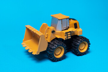 Toy typewriter tractor bulldozer on a blue background. Toy for children