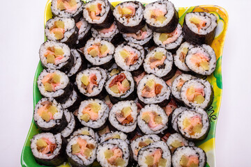 Top view of stack of Japanese sushi maki roll plate. Served in Japanese bar restaurant with chopstick