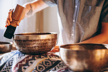 Spa with a masseur and a client who have a relaxing massage with Tibetan music bowls