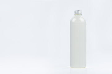 Transparent plastic tall thin bottle with water or cosmetic product, silver cap mockup on white...