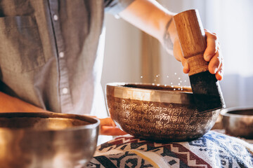 Tibetan copper bowl for meditation, close-up photo on the background of a silhouette of a man
