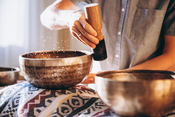 man holding and playing a singing bowl tibetan bowl