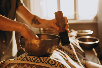 Spa with a masseur and a client who have a relaxing massage with Tibetan music bowls