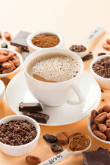 Bowls with aromatic cocoa beans, cocoa nibs, cocoa powder and cup of hot chocolate on natural paper background.