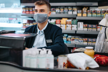 Fototapeta premium Man working in supermarket with a face mask