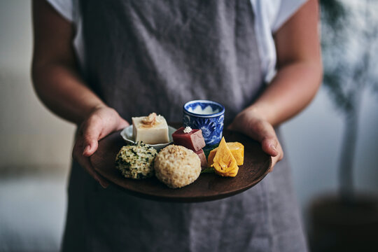 プレートにのせた和食を運ぶ女性の手元