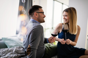 Cheerful happy couple in love drinking wine and having romantic date