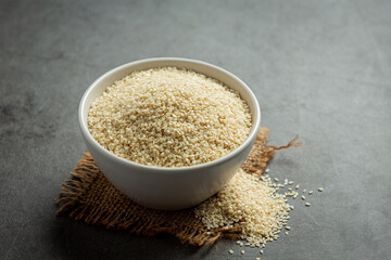 Sesame seeds in bowl on dark background