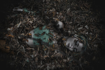 dead girl in autumn foliage wearing green and yellow robes