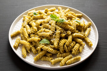 Homemade Pesto Twist Pasta on a plate on a black background, low angle view.