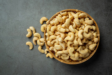 Raw cashews nuts in bowl on dark background