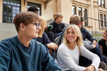 Teenagers talking together in front of school
