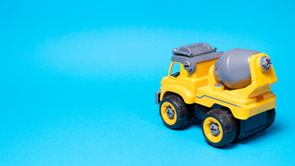 Orange concrete mixer toy typewriter on a blue background. A banner with a place for text for a toy...