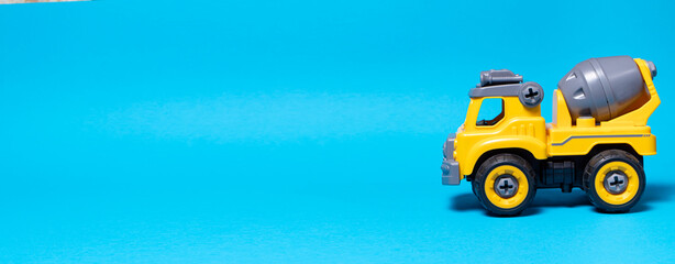Orange concrete mixer toy typewriter on a blue background. A banner with a place for text for a toy...