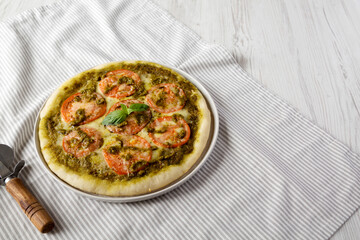 Homemade Pesto Pizza with Fresh Tomatoes and Mozzarella on cloth, side view. Space for text.