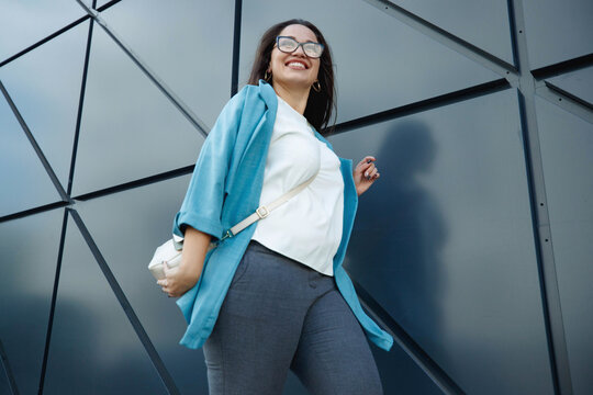 Beautiful stylish overweight woman with mobile phone outdoors. High quality photo
