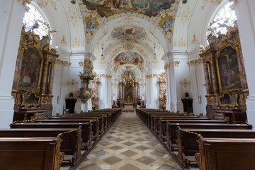 Fototapeta na wymiar View along the main aisle of the church of Schäftlarn Abbey towards the altar. Interior of a typical upper bavarian church.