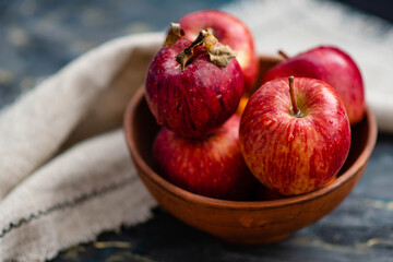 Fresh red apples on a plate on a wooden background. Red apples on a dark background. Selective focus