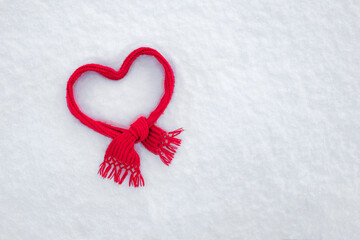 heart from a red scarf on a background of white pure snow, valentine's day background,