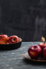 Fresh red apples on a plate on a wooden background. Red apples on a dark background. Selective focus