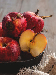 Fresh red apples on a plate on a wooden background. Red apples on a dark background. Selective focus