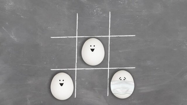 Tic-tac-toe game with healthy and infected sick masked eggs. Health won. Easter 2021