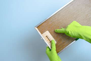  Hand holds a dirty hood filter for cleaning
